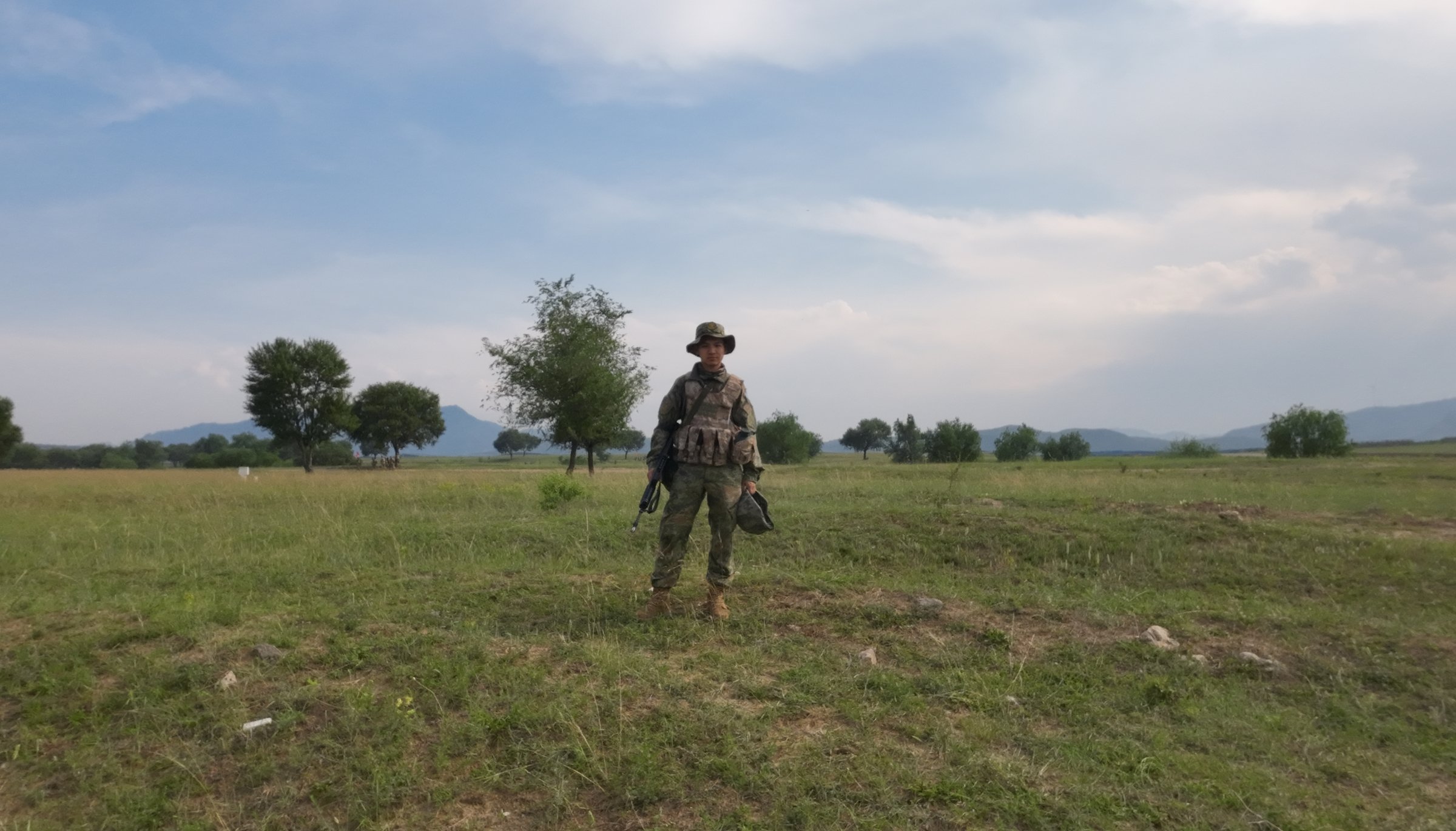 A lone figure on open grassland under a wide sky